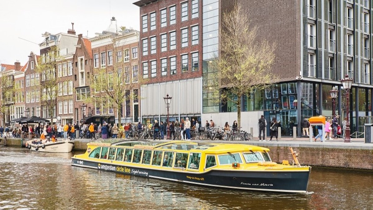 a small boat in a body of water with a city in the background